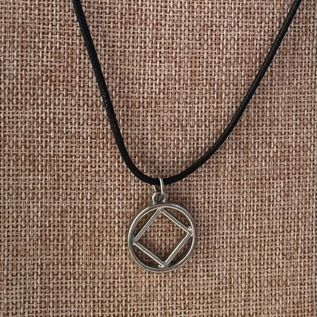 A silver-colored alloy necklace with a hypoallergenic clasp, featuring a Narcotics Anonymous symbol pendant on a textured background.