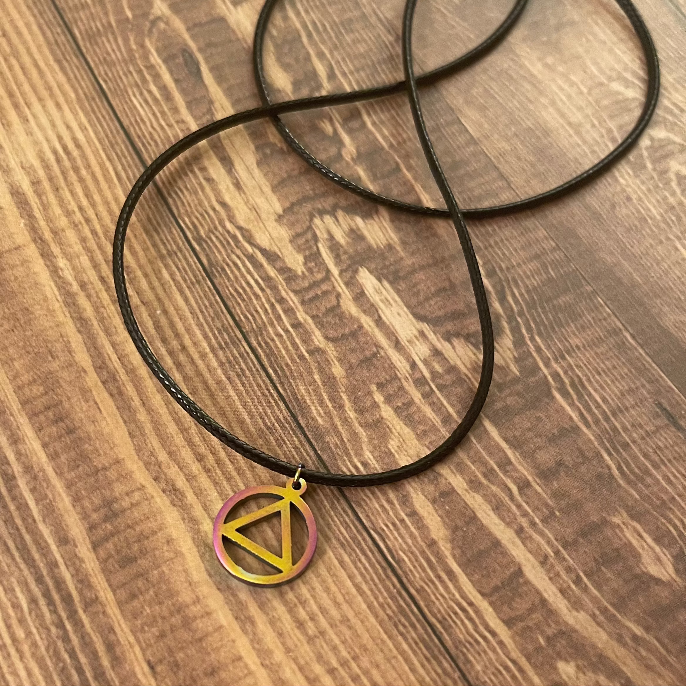 Necklace with a triangle pendant on a wooden surface